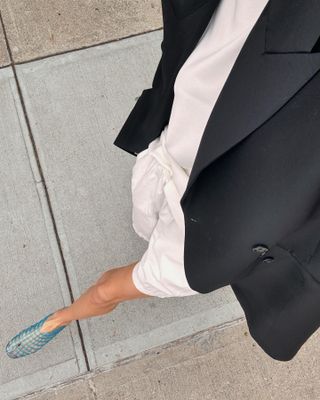 Woman in jelly shoes and white shorts.